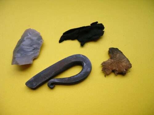The contents of a tinder box, with charred cloth, a piece of dried mushroom, a piece of flint and a piece of metal for making sparks with the flint