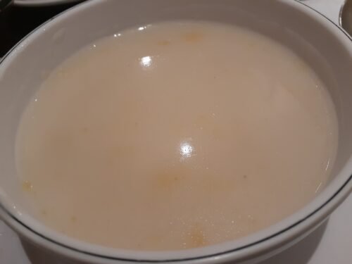 Creamy white soup in a white porcelain bowl.
